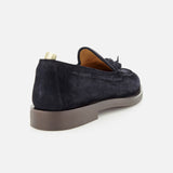 The OFFICINE CREATIVE Opera Flexi Tassel Loafer is shown from the rear left side on a white background, featuring dark suede with tassels, a tan interior, beige pull tab, and a thick grey sole.