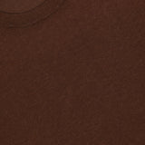 Close-up of the Boris Loose Knit T-shirt by OFFICINE GÉNÉRALE, featuring a brown crew neck, soft knit texture, and loose fit. A white label inside the collar displays the brand name.