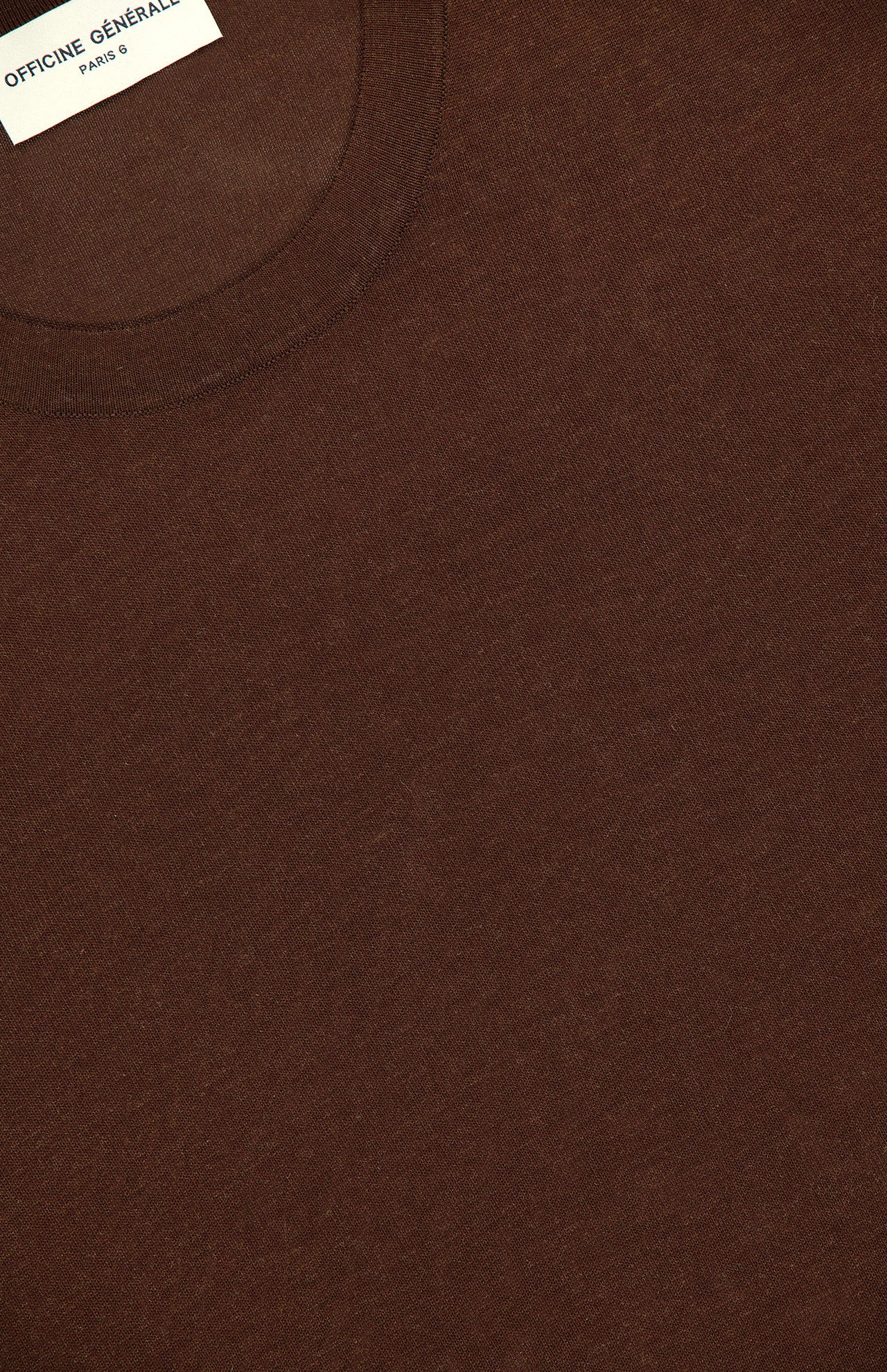 Close-up of the Boris Loose Knit T-shirt by OFFICINE GÉNÉRALE, featuring a brown crew neck, soft knit texture, and loose fit. A white label inside the collar displays the brand name.