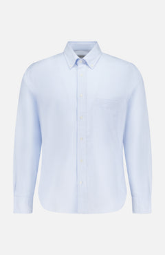 The Candy Stripe Oxford Shirt by OFFICINE GÉNÉRALE features light blue stripes, long sleeves, a classic collar, and chest pocket, crafted from fine Italian cotton for timeless Parisian style. Displayed on a plain white background.