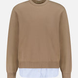 The OFFICINE GÉNÉRALE Darius Suprpo Stripe Shirt is a tan cotton crew neck pullover with ribbed cuffs and hem, featuring blue and white striped fabric layered at the bottom, shown on a plain white background.