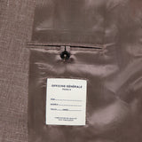 A close-up of the Leon Double Breasted Poplin Blazer by OFFICINE GÉNÉRALE shows its light brown interior, featuring a labeled inner pocket with a button. The label includes spaces for name, model, size, and year.