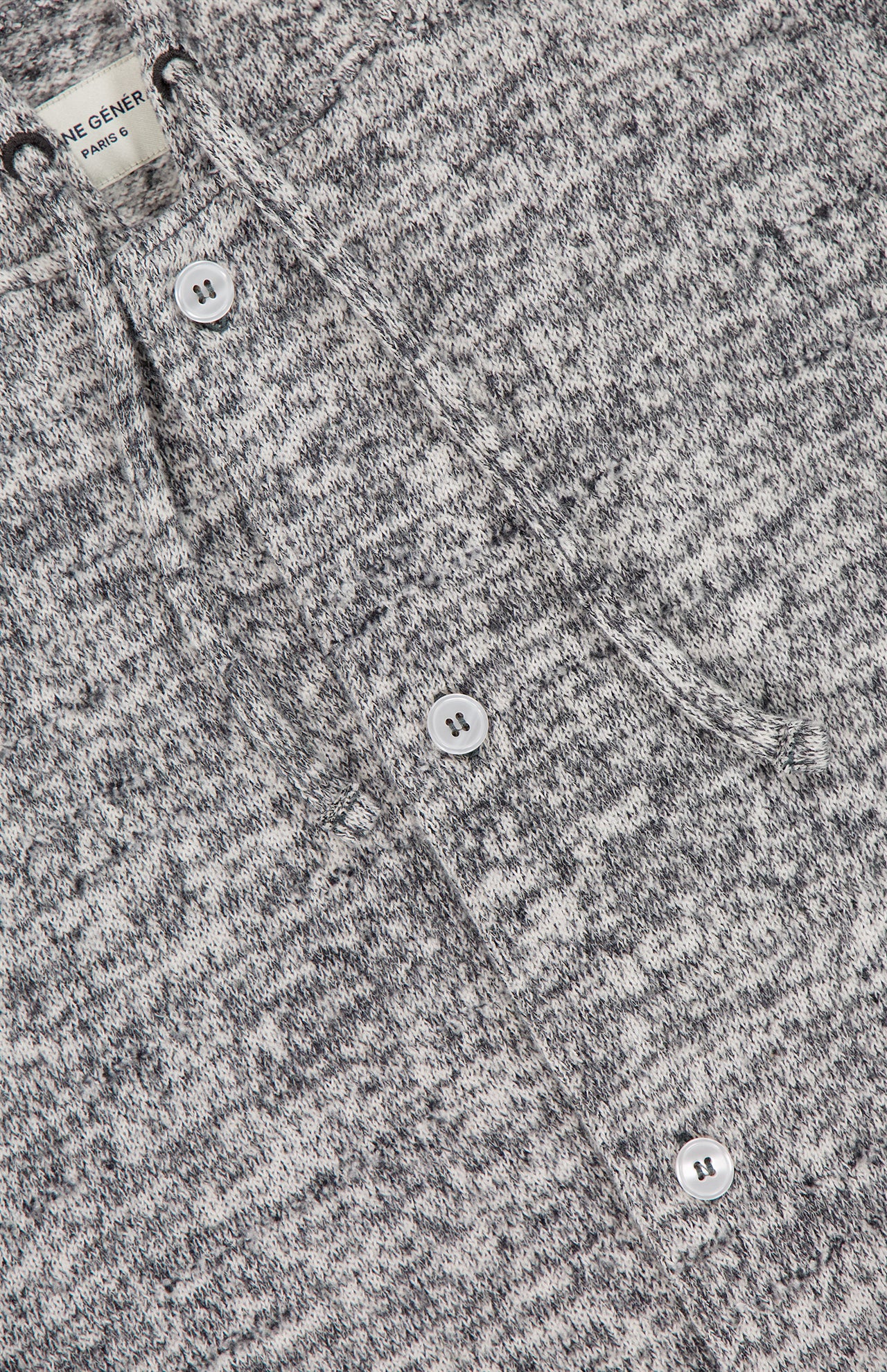 Close-up of the Melange Basile Drawstring Hoodie by OFFICINE GÉNÉRALE, featuring marled grey fabric, a chest patch pocket, white buttons, and a partially visible label at the collar.