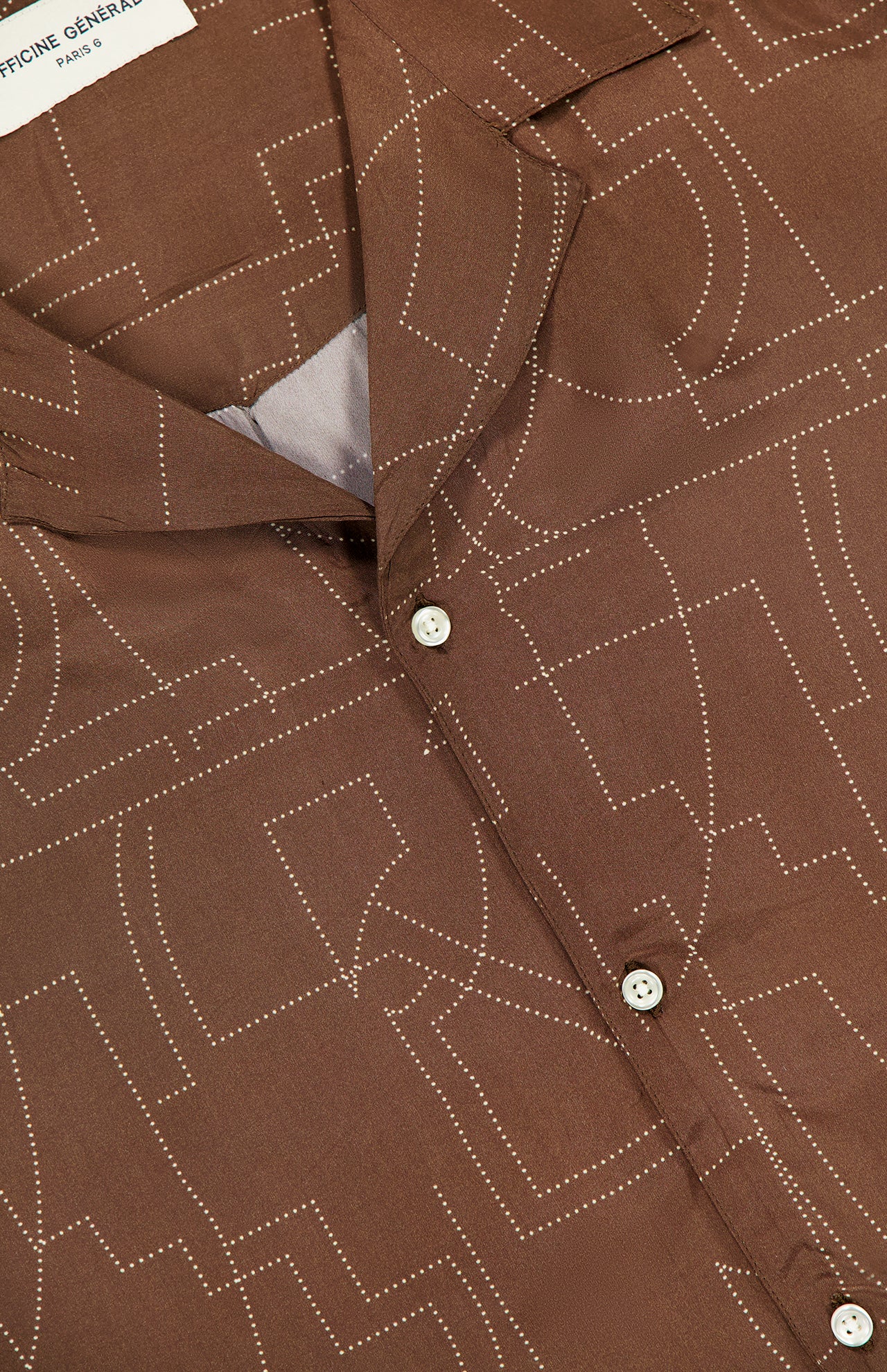 Close-up of the Eren Short Sleeve Crepe Dot Design Shirt by OFFICINE GÉNÉRALE, showcasing a brown geometric dotted pattern and a visible white collar label.