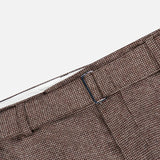 Close-up of the waistband and upper section of OFFICINE GÉNÉRALE’s Hoche Wool Trouser Pants in light brown, featuring a textured finish, belt loop, visible lining, and a removable belt.