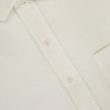 Close-up of the Jordy Pigment Brush Twill Long Sleeve Shirt in cream cotton, featuring a casual collar with three buttons, a visible chest pocket, and an OFFICINE GÉNÉRALE brand label on the inside of the collar.