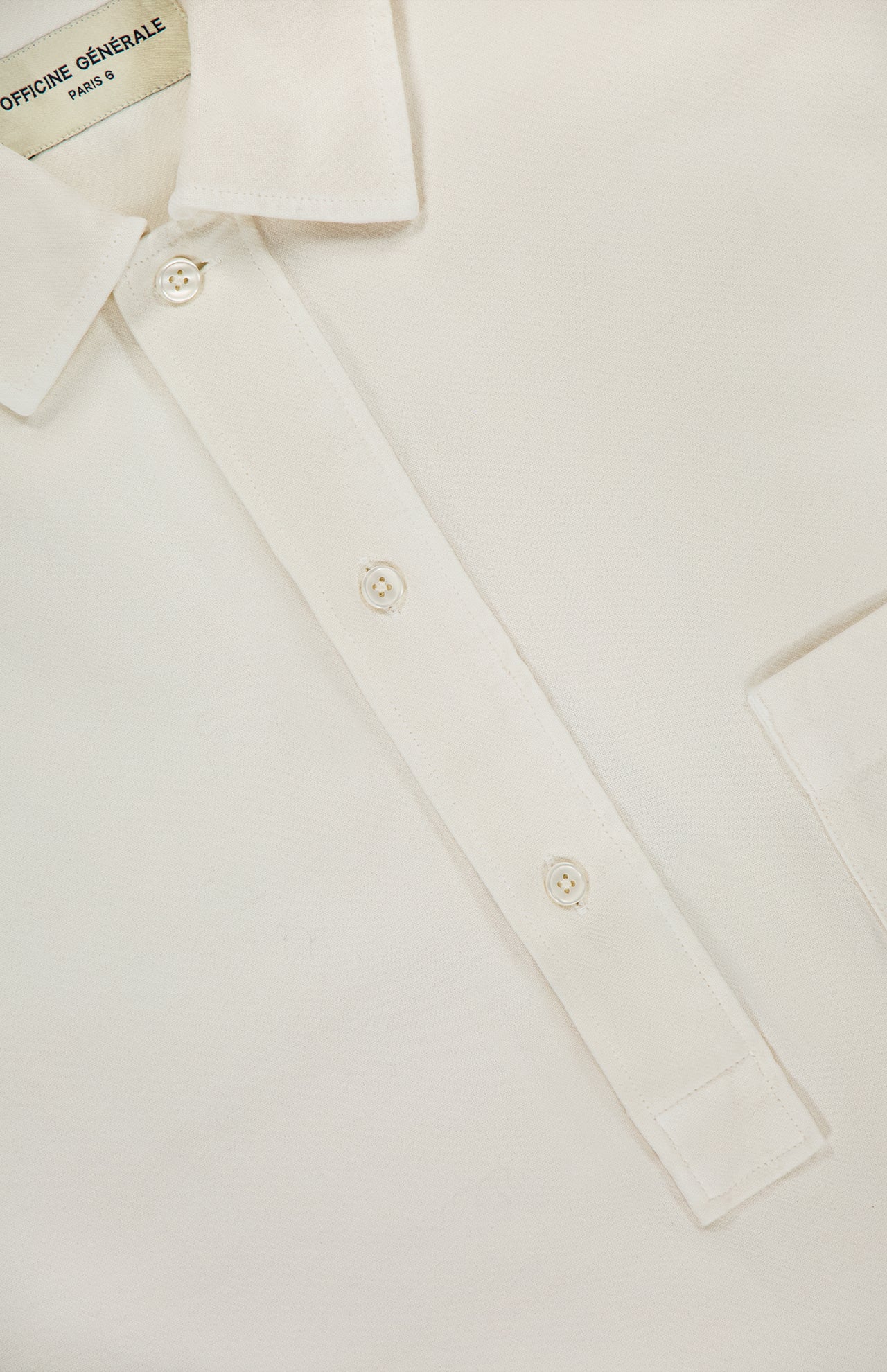 Close-up of the Jordy Pigment Brush Twill Long Sleeve Shirt in cream cotton, featuring a casual collar with three buttons, a visible chest pocket, and an OFFICINE GÉNÉRALE brand label on the inside of the collar.