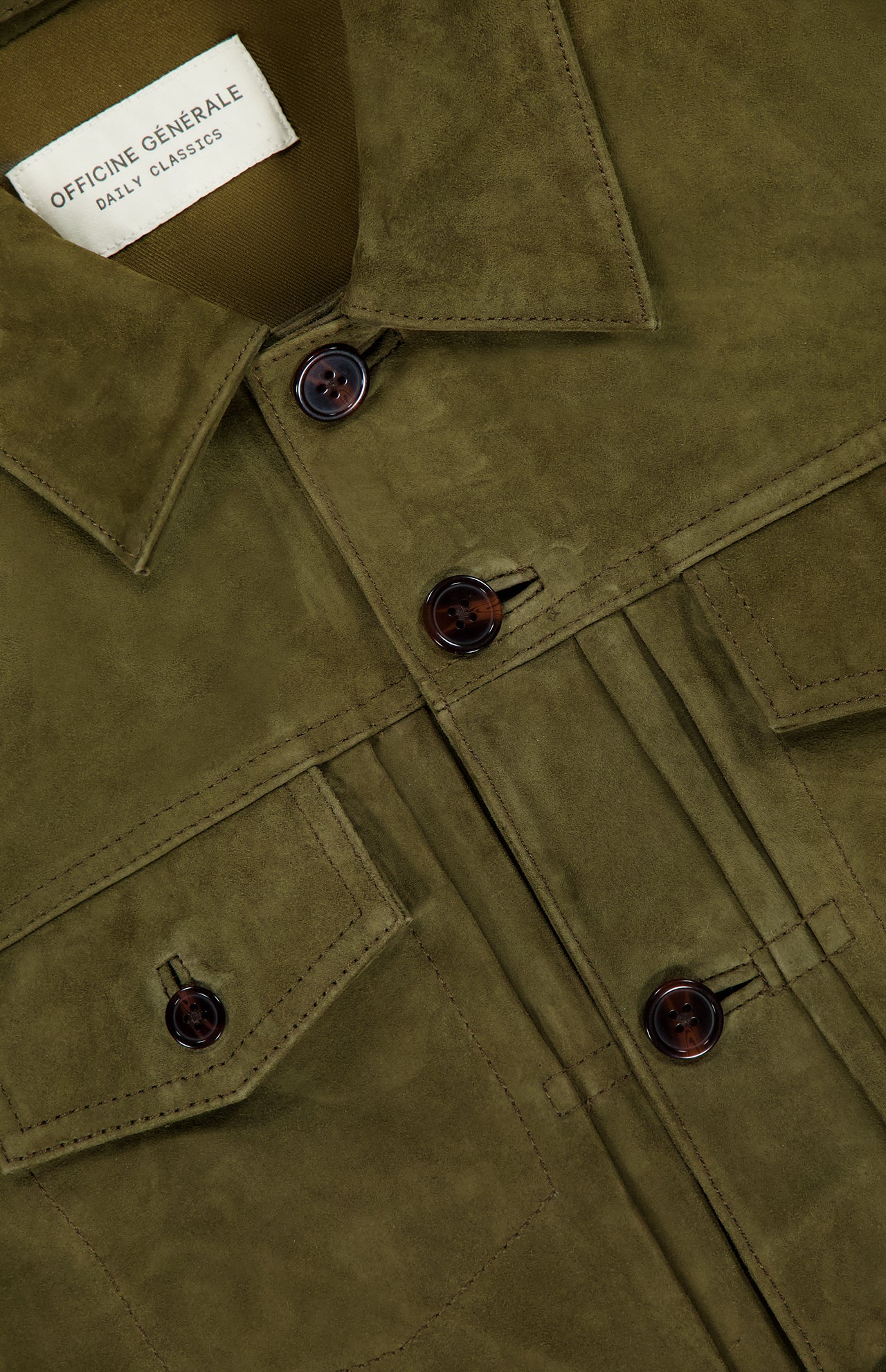 Close-up of the OFFICINE GÉNÉRALE Liam Goat Leather Suede Jacket in olive green, featuring brown buttons, two chest pockets, and a visible Daily Classics label.