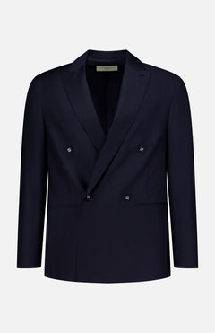 The OFFICINE GÉNÉRALE Merrick Twill Double Breasted Jacket is expertly tailored from virgin wool in a dark navy hue, featuring peak lapels, four front buttons, and two front pockets. It is showcased against a plain white background.