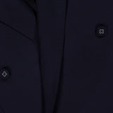 Close-up of the OFFICINE GÉNÉRALE Merrick Twill Double Breasted Jacket in dark navy, highlighting its double-breasted design with four round buttons featuring a small white center detail. The smooth twill fabric showcases the refined texture characteristic of a virgin wool blazer, while partially visible lapels complete the sophisticated look.
