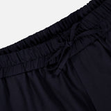 Close-up of the waistband of the OFFICINE GÉNÉRALE Nelson Twill Trouser Pants in dark navy, featuring a drawstring tie, gathered elastic material, and part of the upper pant legs set against a plain light background.