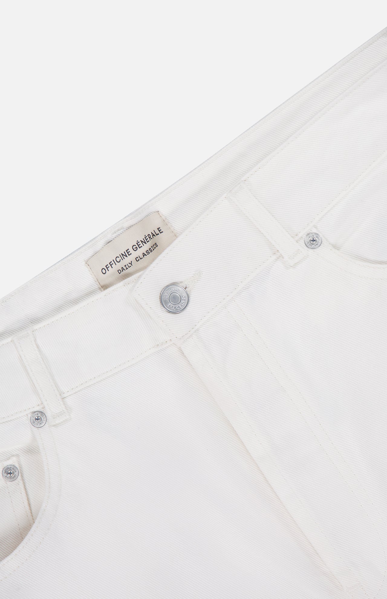 Close-up of the waistband and front pockets of OFFICINE GÉNÉRALE Vintage Original Wash Denim Pants, featuring silver buttons, classic 5-pocket design, and an inner label with the brand name.