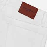 Close-up of the back pocket and waistband of OFFICINE GÉNÉRALE Vintage Original Wash Denim Pants, featuring a brown leather brand patch, visible belt loops, subtle stitching, and classic 5-pocket design.