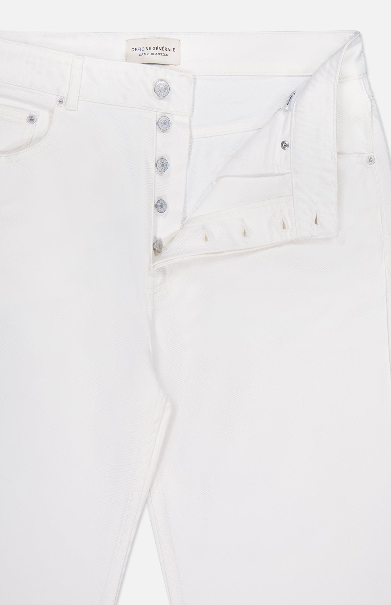 OFFICINE GÉNÉRALE Vintage Original Wash Denim Pants: off-white jeans with a partially open button fly revealing silver buttons, front pockets, classic 5-pocket design, and a visible inner label by the waistband.