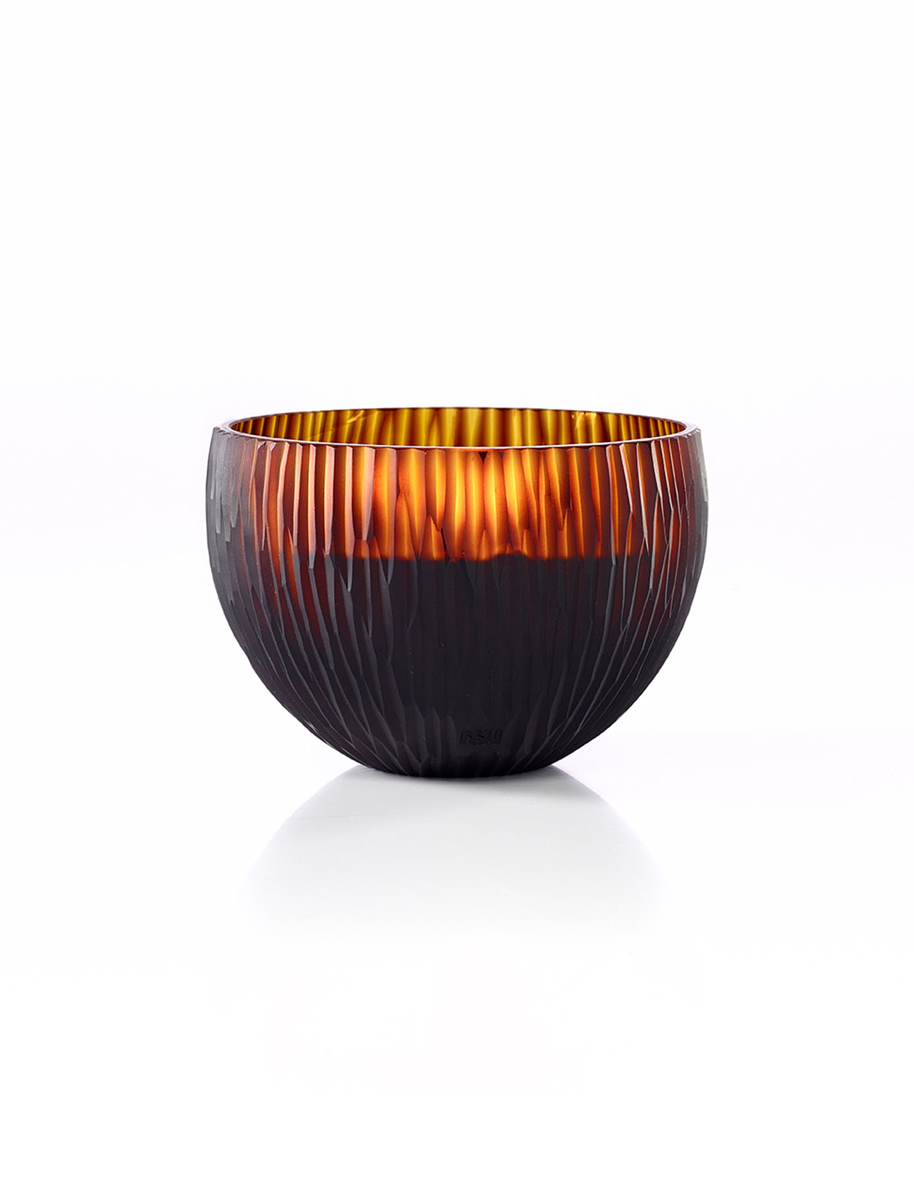 The ONNO Amber Ellipse L Ginger Fig Candle is shown against a white background. Its round, amber glass bowl features a ribbed texture and glows warmly inside, highlighting the candle's translucent quality and inviting ambiance.