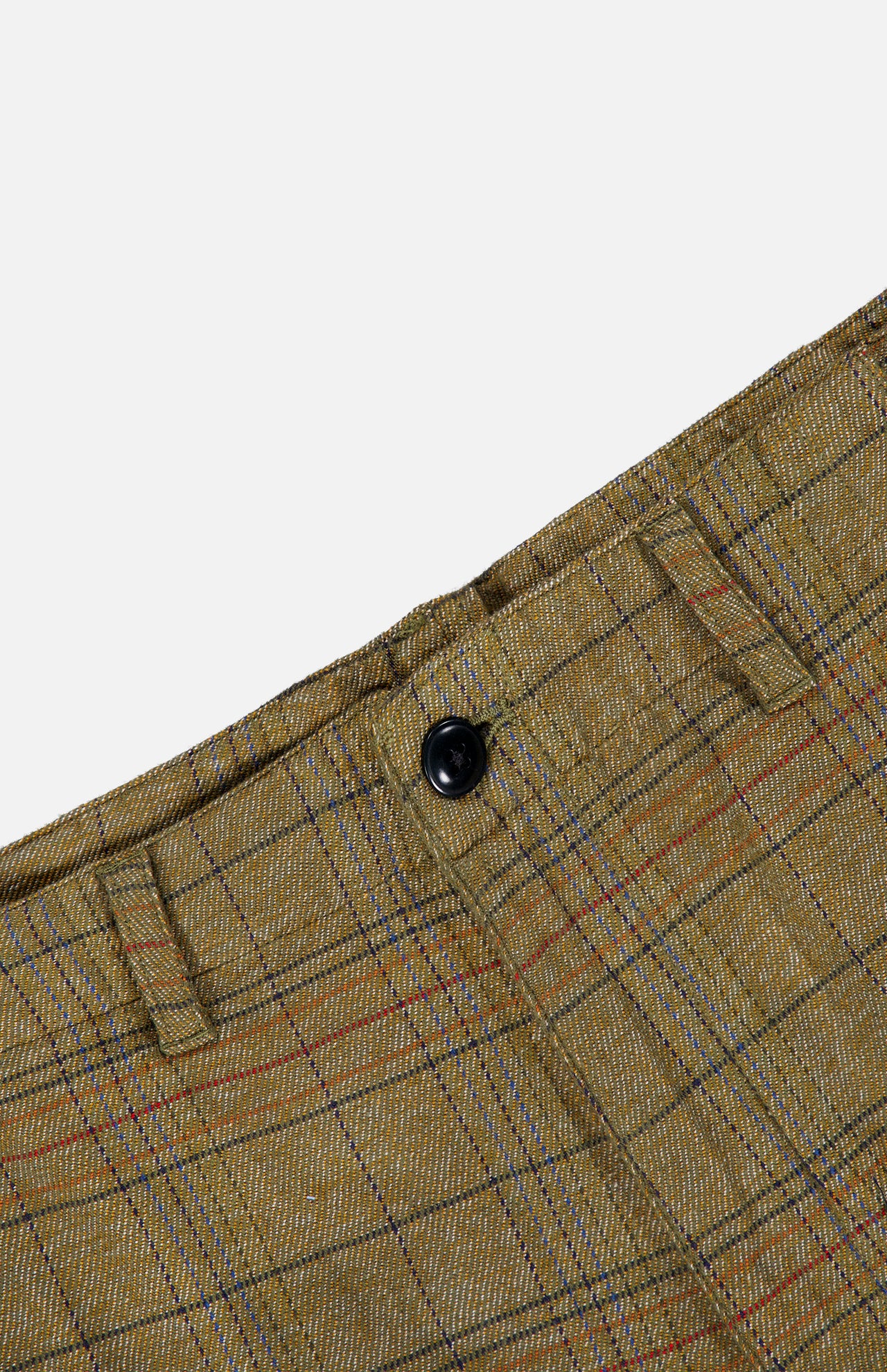 Close-up of the Check Trouser Pant by ORIGINAL MADRAS, featuring brown plaid fabric with belt loops and a black button at the waistband. The distinctive Madras check pattern in red and blue lines highlights these classic cotton trousers, made in India.