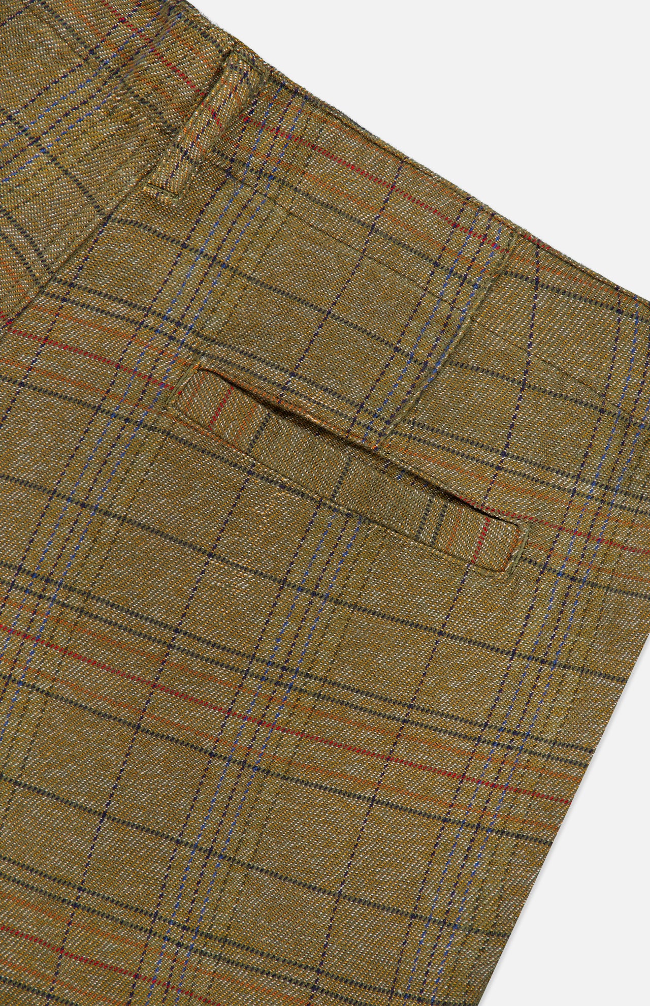 Close-up of the ORIGINAL MADRAS Check Trouser Pant, featuring brown tweed fabric with a plaid pattern in red, blue, and black lines, showcasing a back pocket and part of a seam—a garment likely crafted from cotton and made in India.