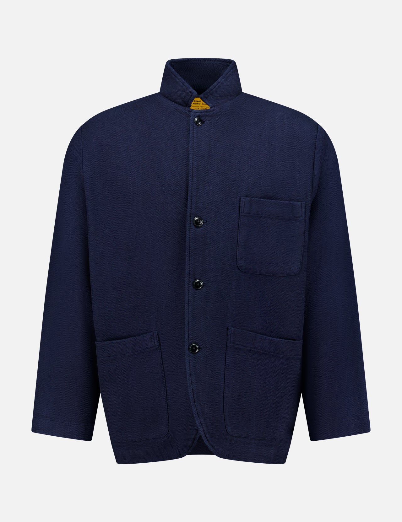 The ORIGINAL MADRAS Herringbone Twill Soft Jacket is crafted from navy cotton with a subtle herringbone pattern. It features a classic button-up design, a stand collar, and three front pockets, and is displayed on a plain white background.