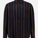The Pinstripe Roundtail Overshirt by ORIGINAL MADRAS is a long-sleeve, button-up black overshirt made from premium Indian cotton, designed with vertical yellow, red, and orange pinstripes and finished with two chest pockets. It is displayed against a plain white background.