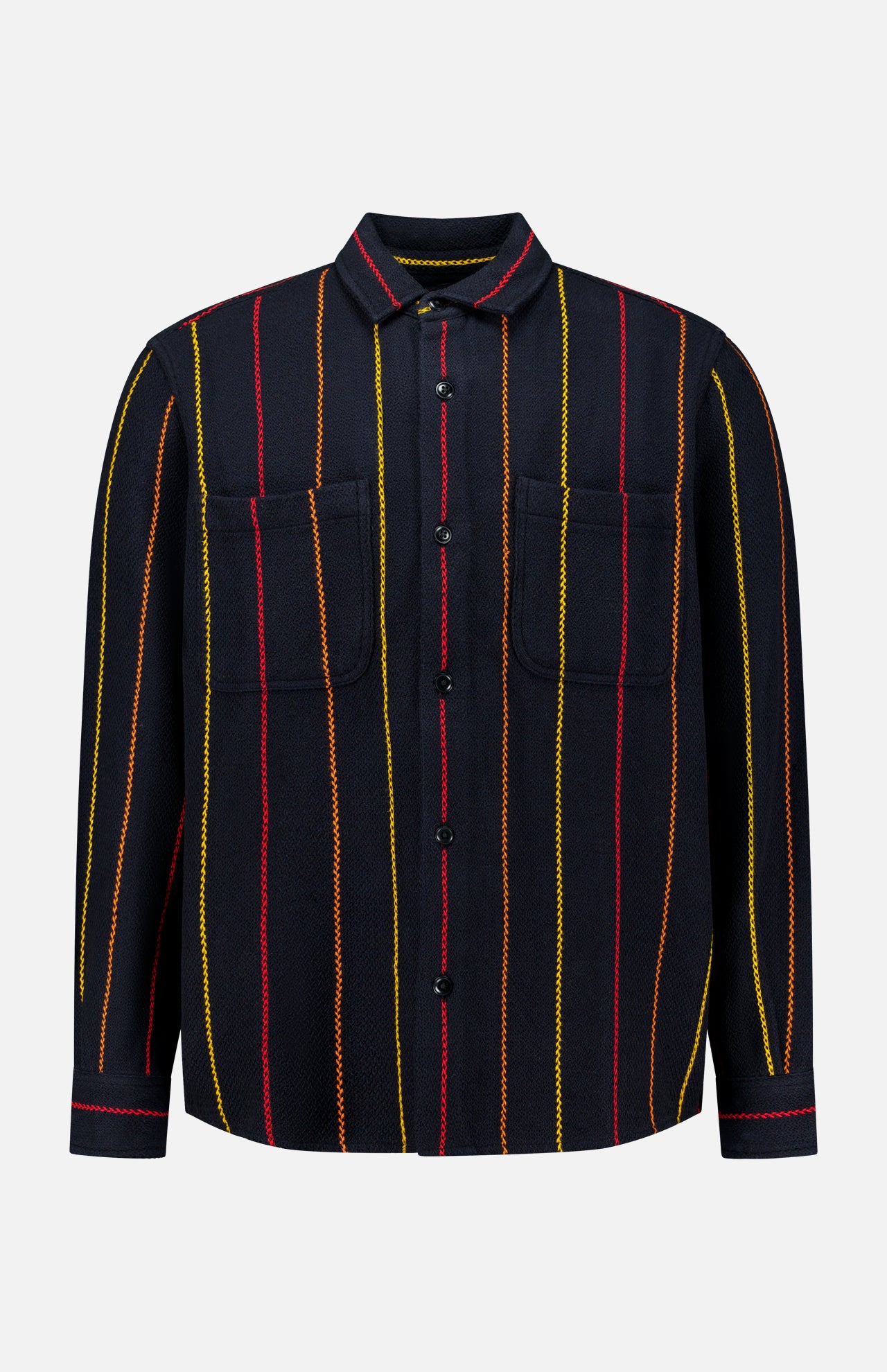 The Pinstripe Roundtail Overshirt by ORIGINAL MADRAS is a long-sleeve, button-up black overshirt made from premium Indian cotton, designed with vertical yellow, red, and orange pinstripes and finished with two chest pockets. It is displayed against a plain white background.