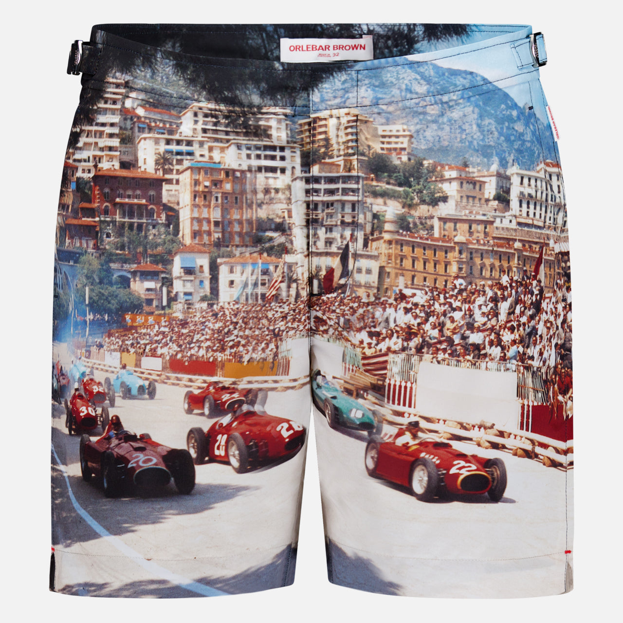 ORLEBAR BROWN Bulldog Photographic Race Car Shorts feature a vivid Grand Prix de Monaco print with classic race cars speeding past grandstands, city buildings, and mountains in the background.