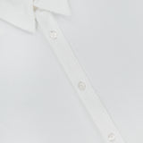 Close-up of the Giles Slim Fit Pique Shirt by ORLEBAR BROWN in Italian-woven cotton, partially unbuttoned with a visible red ORLEBAR BROWN size M label inside the collar.