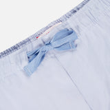 Close-up of the waistband of ORLEBAR BROWN's Alex Relaxed Linen Pants in light blue, featuring an elastic band and a matching fabric bow at the center front. The soft linen material looks lightweight and comfortable.
