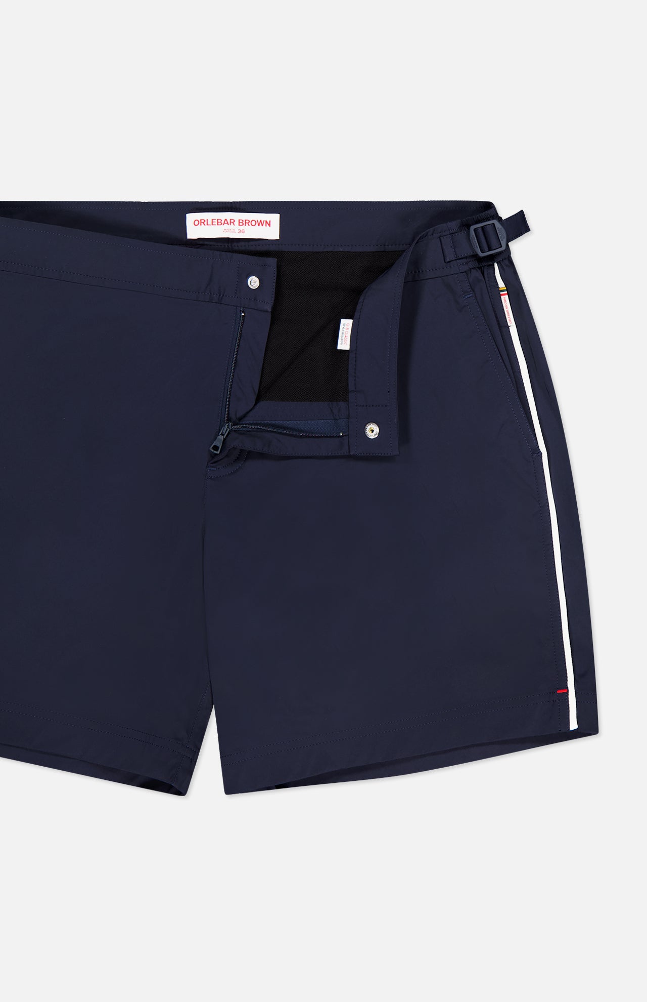 ORLEBAR BROWN Bulldog Stretch Shorts in navy, featuring a side buckle, adjustable side tabs, button closure, and white vertical stripe detail. The inner waistband displays the brand name.