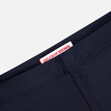 Close-up of Bulldog Stretch Shorts by ORLEBAR BROWN, showing a white inner waistband label with red branding and adjustable side tabs, set against a plain light background.