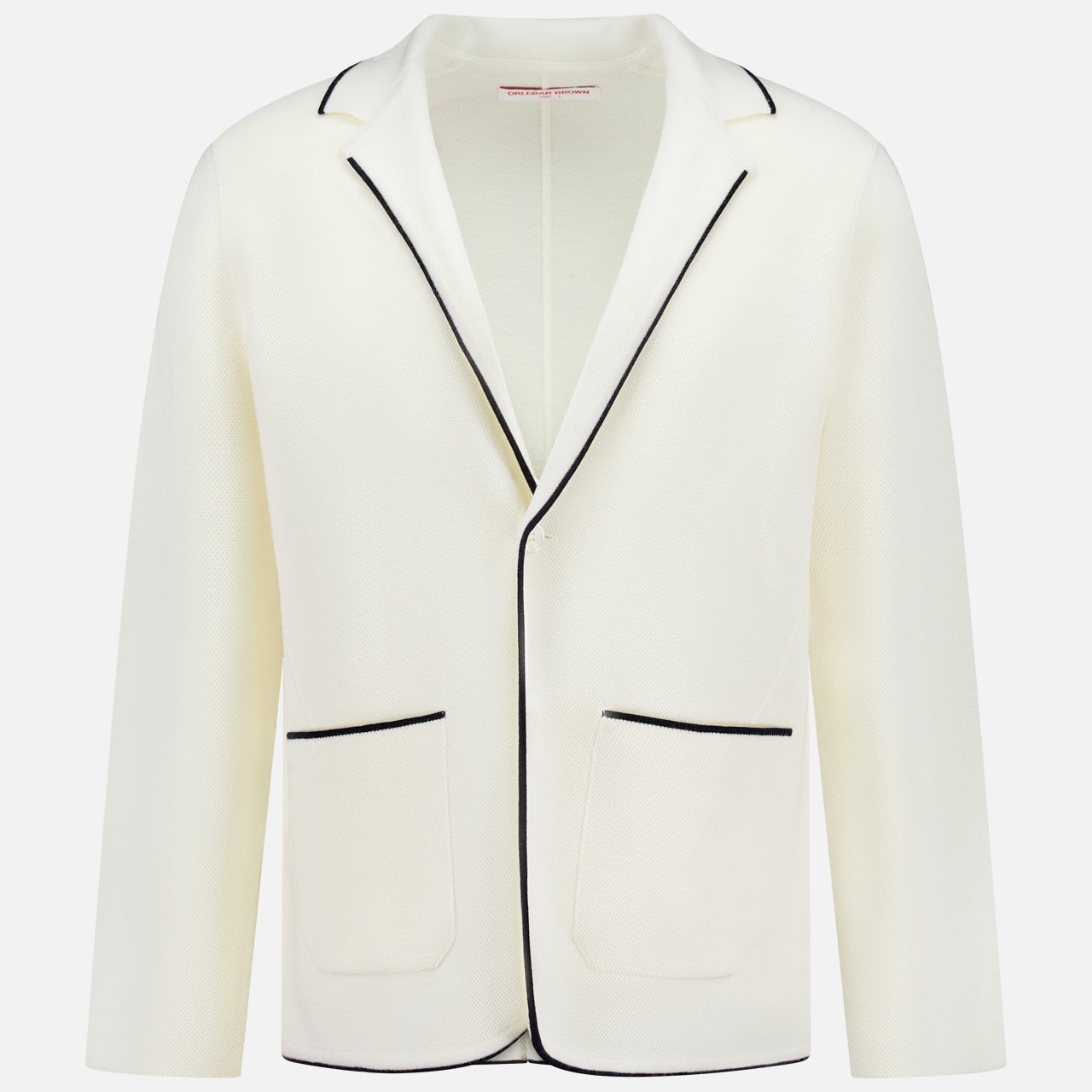 The Rainer Tipping Cardigan by ORLEBAR BROWN is a white cardigan-blazer with black piping on the collar, lapels, front opening, and pocket edges. With two front patch pockets and a minimal look, it’s ideal for modern summer tailoring.