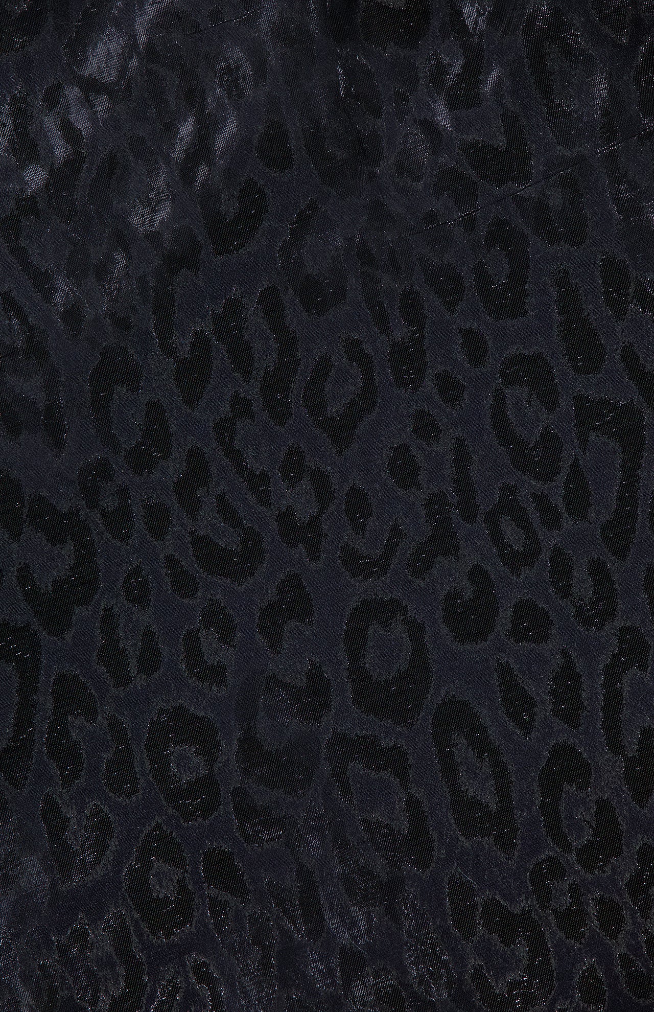 Close-up of the PAMELLA ROLAND Lurex Jacquard Mini Dress in black, showcasing a subtle leopard print with dark spots and a slightly shiny, textured finish—ideal for a chic, animal-inspired look.
