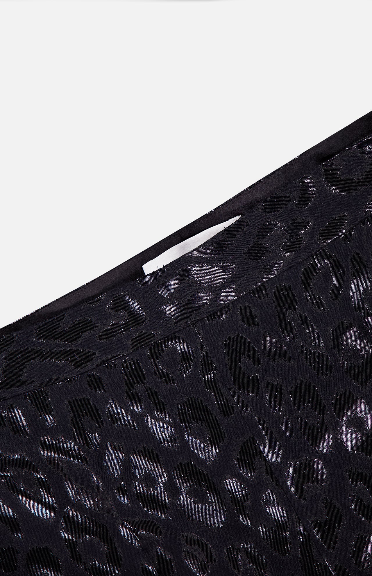 Close-up of PAMELLA ROLAND’s Lurex Jacquard Leopard Print Pant, featuring a black velvet fabric with shiny leopard pattern and detailed waistband—a bold statement piece designed to stand out.