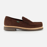 The Paraboot Nantes Slip On Loafer features brown suede, a moccasin-style toe with visible stitching, Norwegian welt construction, a tan rubber sole, and a small green side tag, shown against a plain white background.