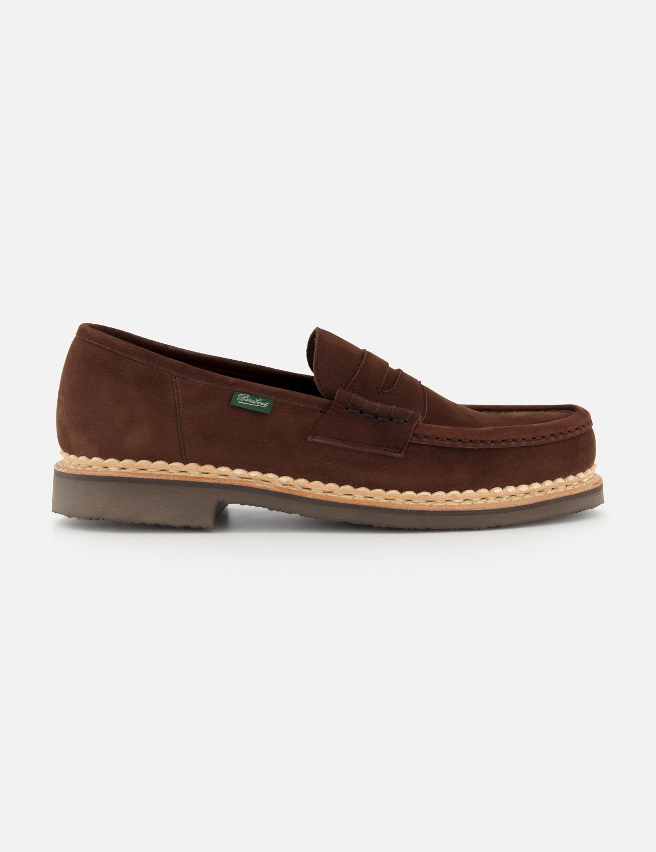 The Paraboot Nantes Slip On Loafer features brown suede, a moccasin-style toe with visible stitching, Norwegian welt construction, a tan rubber sole, and a small green side tag, shown against a plain white background.
