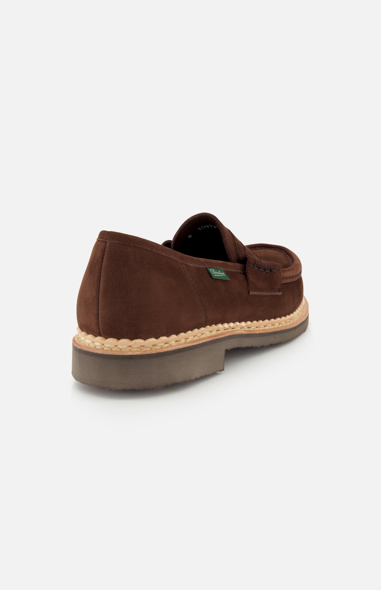 The Paraboot Nantes Slip On Loafer features brown suede with a beige woven trim above a thick rubber sole, crafted using Norwegian welt construction, shown from the back against a plain white background.