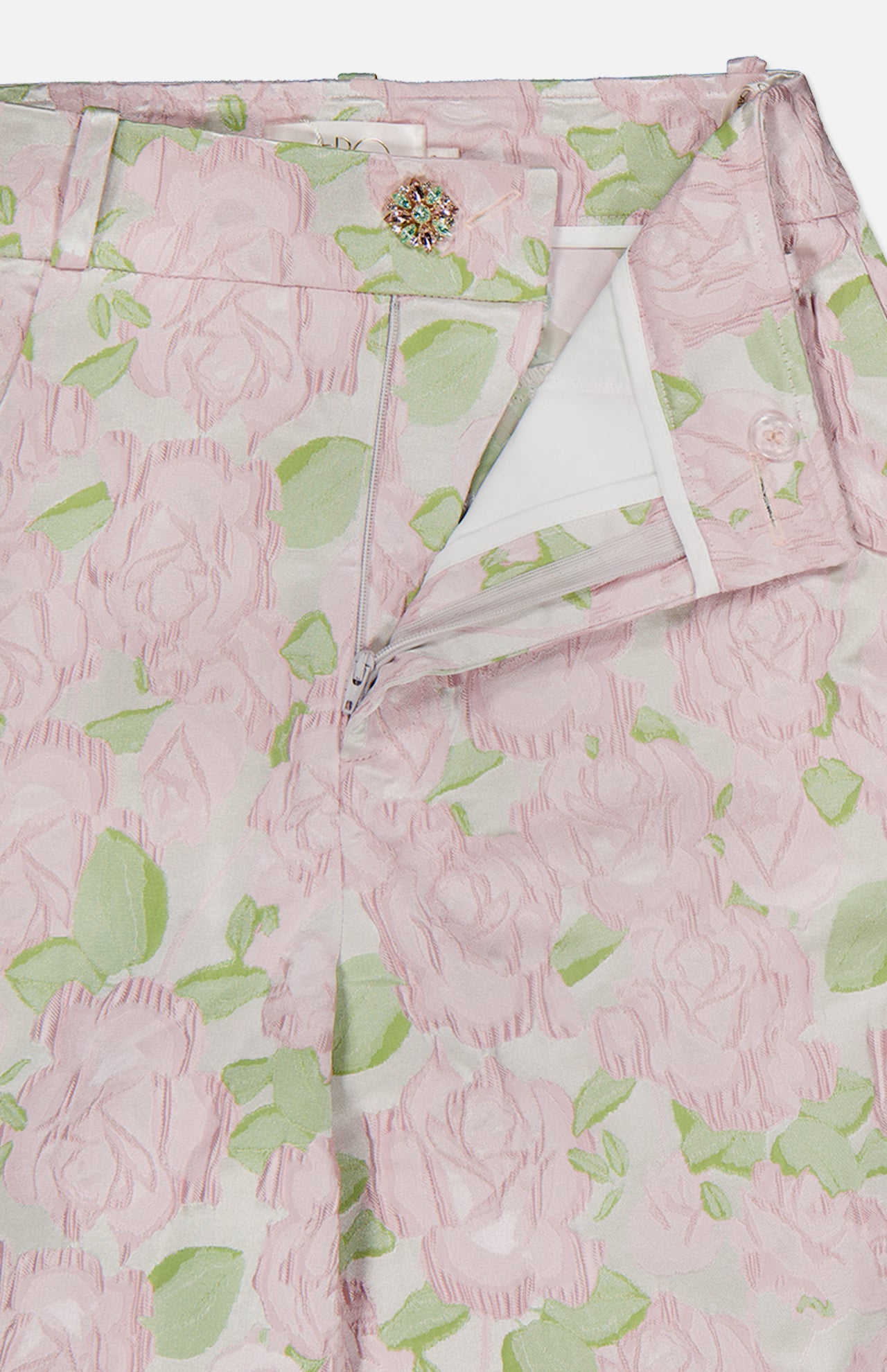 Close-up of PATBO’s Garden Jacquard Pants, featuring a pastel pale pink and green pattern, a partially open zipper, and a decorative button at the waistband—perfect for achieving a feminine, garden party aesthetic.