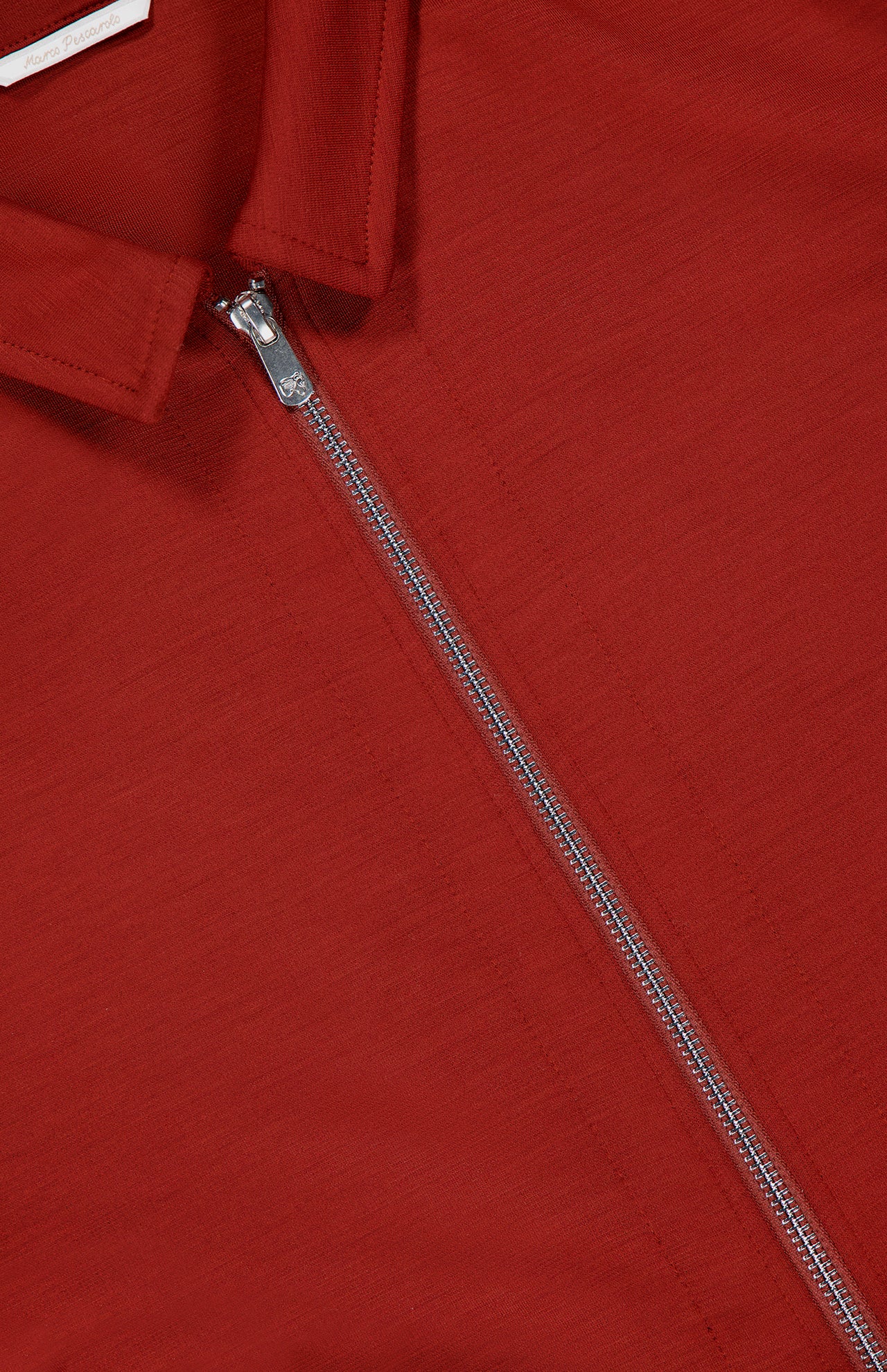 Close-up of the PESCAROLO Avi Wool Jersey Zip Unlined Jacket, a red piece with Italian-inspired smooth fabric and a silver zipper running from chest to collar, partially unzipped for a stylish touch.