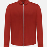 The Avi Wool Jersey Zip Unlined Jacket by PESCAROLO is a plain, long-sleeved red virgin wool jacket with a front zip and small collar—an understated example of Italian elegance, shown on a white background.
