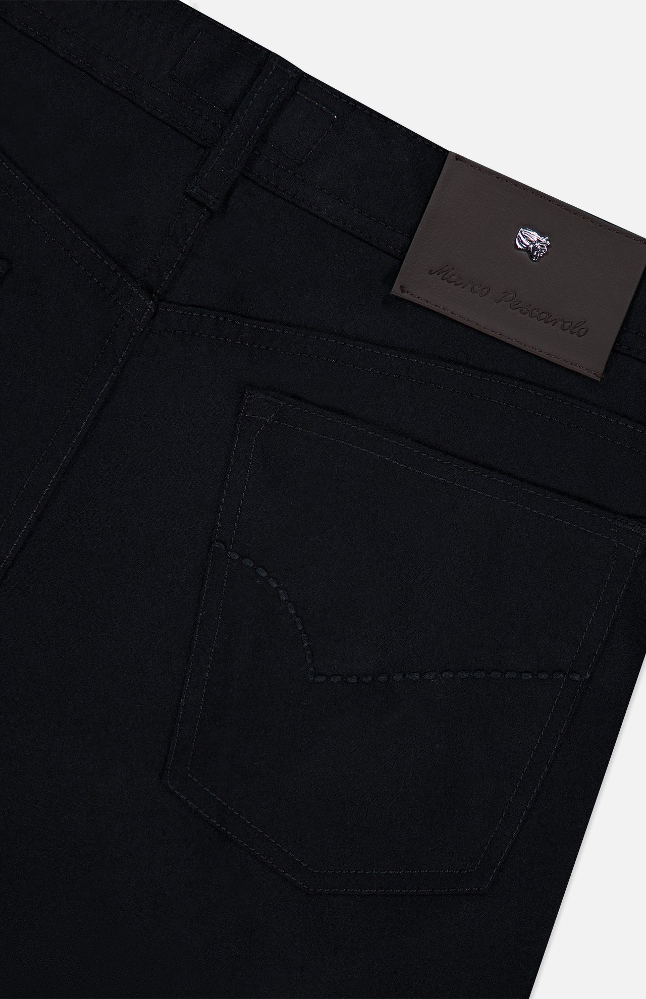 Close-up of the back pocket and waistband of the PESCAROLO Nerano M Cashmere Pants, featuring intricate stitching and a dark leather patch embossed with text and a small logo above the pocket. The classic 5-pocket design enhances the timeless appeal of these black cashmere pants, showcasing exceptional craftsmanship.