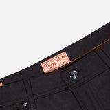 Close-up of the waistband and button of the dark-colored PESCAROLO Nerano M Cashmere Pants, highlighting a red Pescarolo brand label sewn on the inside. These premium pants, made in Italy, showcase meticulous attention to detail.