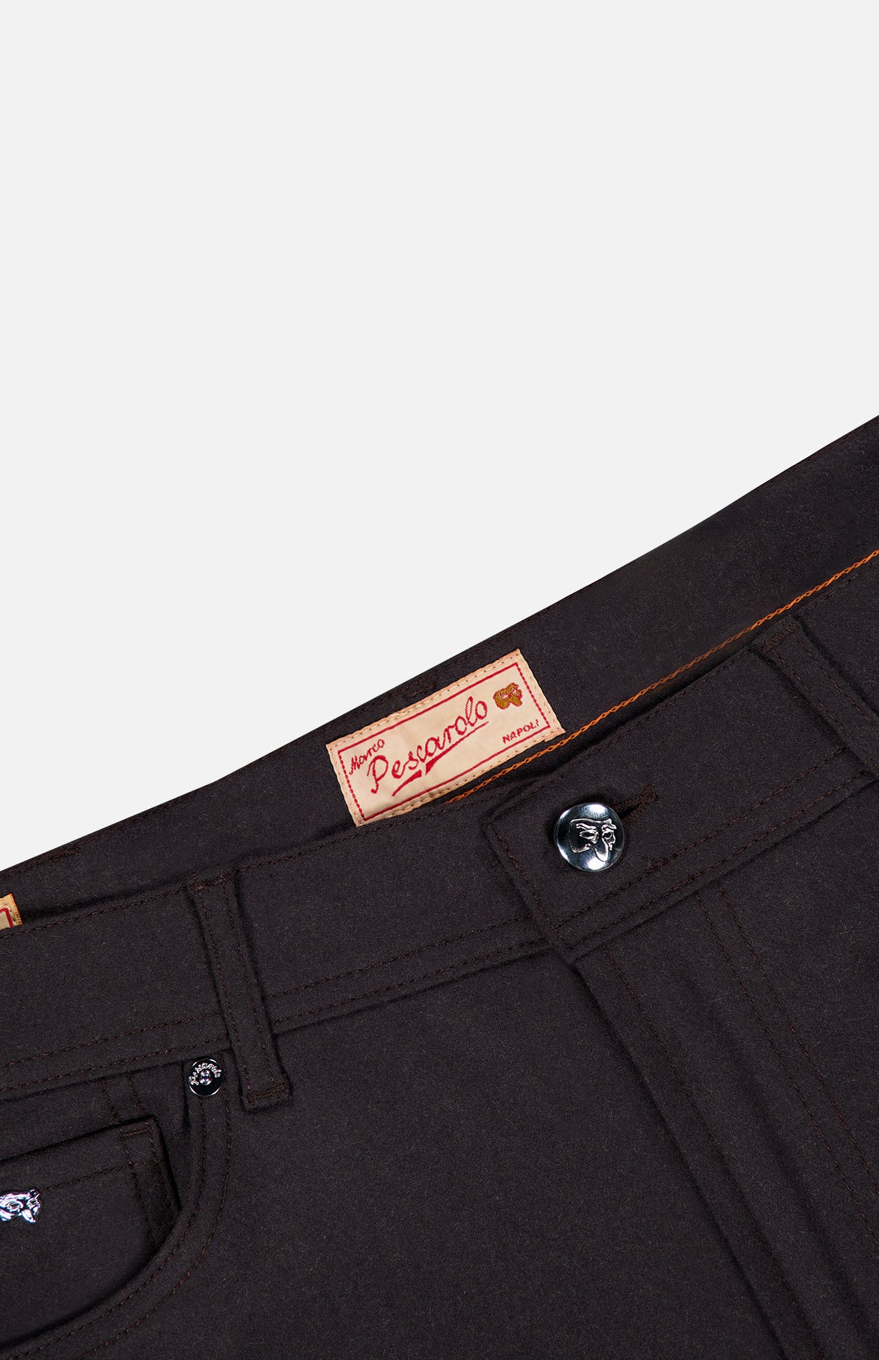 Close-up of the waistband and button of the dark-colored PESCAROLO Nerano M Cashmere Pants, highlighting a red Pescarolo brand label sewn on the inside. These premium pants, made in Italy, showcase meticulous attention to detail.