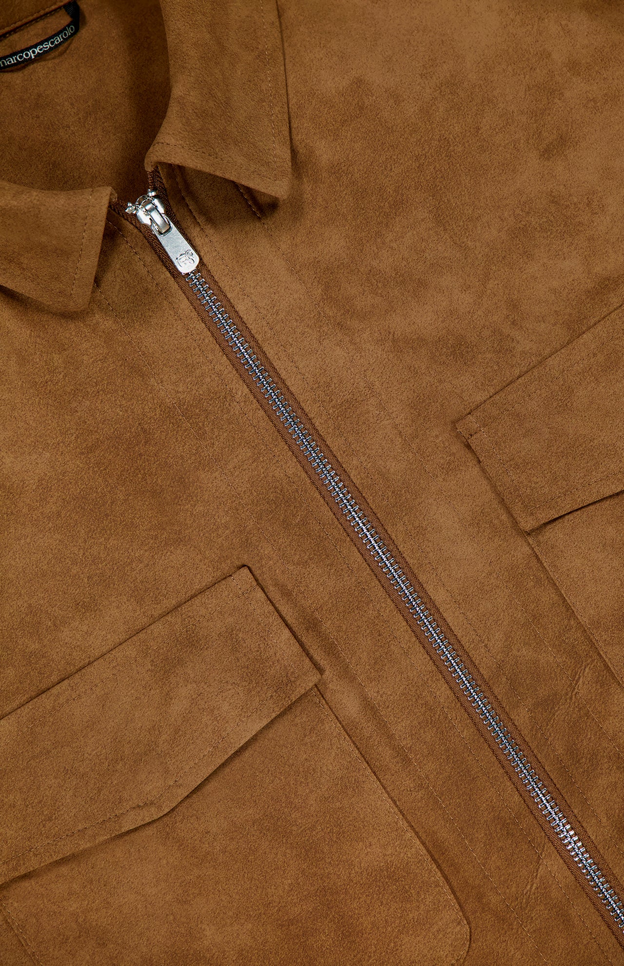 Close-up of the Urus Faux Suede Zip Jacket by PESCAROLO, showing a brown faux suede finish, silver zipper, two flap chest pockets, and a classic collar—reflecting Italian craftsmanship and premium material quality.