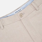 Close-up of the Charlotte Performance Trouser Pant by PETER MILLAR in beige stretch mélange fabric, featuring a button closure, belt loops, and a striped light blue and white waistband with a visible Peter Millar label.