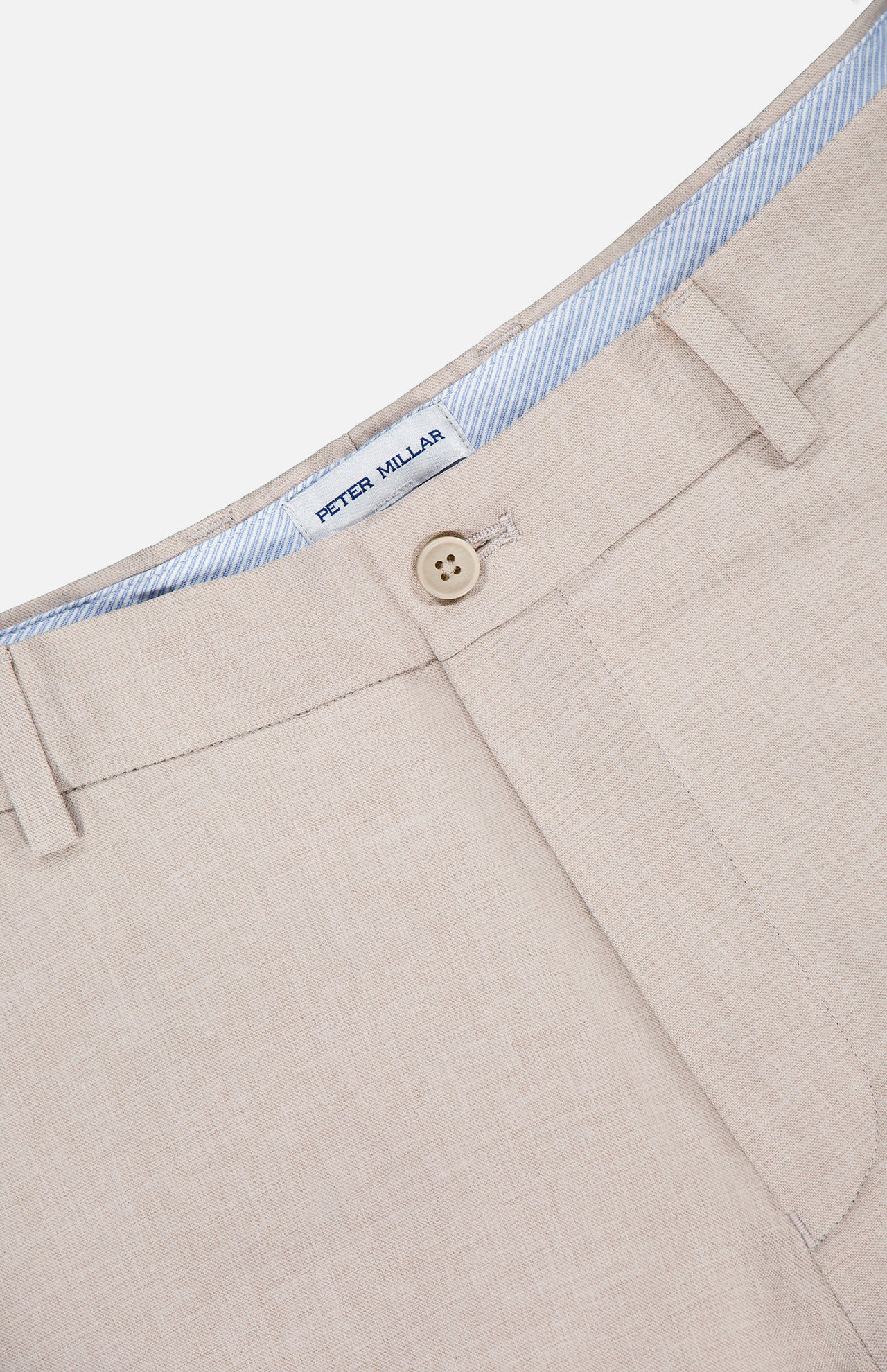 Close-up of the Charlotte Performance Trouser Pant by PETER MILLAR in beige stretch mélange fabric, featuring a button closure, belt loops, and a striped light blue and white waistband with a visible Peter Millar label.