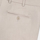 Close-up of the back of the PETER MILLAR Charlotte Performance Trouser Pant in beige stretch mélange fabric, featuring a belt loop, welt pocket with button closure, and a small embroidered logo above the pocket.