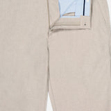 The Charlotte Performance Trouser Pant by PETER MILLAR features a beige design with a light blue and white striped inner lining, button closure, and belt loops at the waist, crafted from soft stretch mélange fabric for comfort.