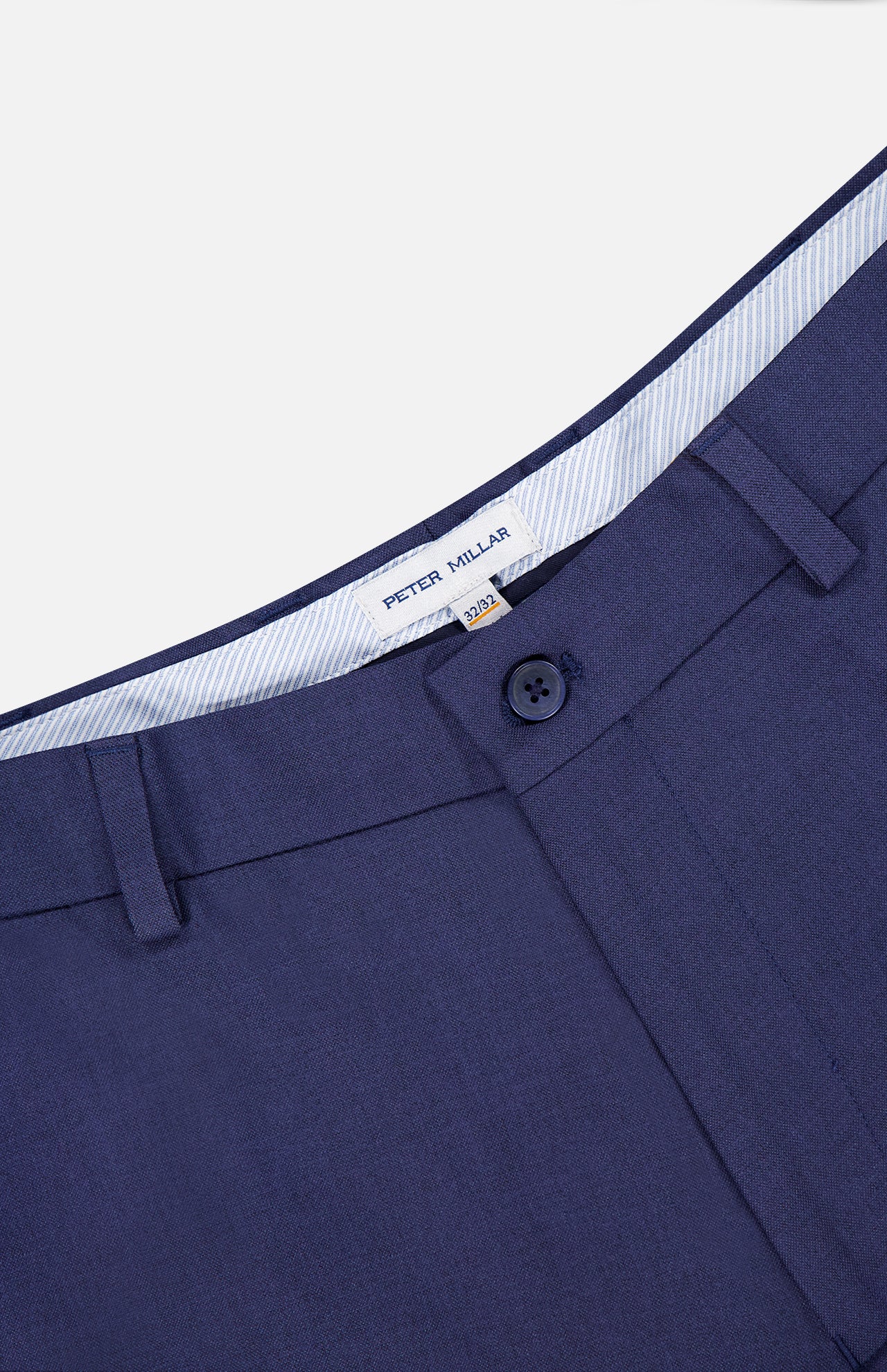 Close-up of the waistband and upper section of the Charlotte Performance Trouser Pant by PETER MILLAR in navy stretch mélange, showing button closure, belt loops, and an inner PETER MILLAR label.