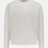 The PETER MILLAR Cradle Pique Performance Long Sleeve Sweatshirt features a relaxed fit, off-white textured piqué fabric, subtle four-way stretch, and long sleeves, shown against a white background.