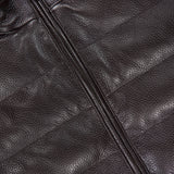 Close-up of a dark brown textured Deerskin Leather Vest with a visible zipper and PETER MILLAR label on the inside collar, featuring merino wool lining for added comfort—an exceptional choice in luxury outerwear.
