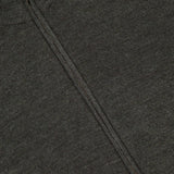 Close-up of the Excursionist Flex Full Zip Sweater by PETER MILLAR in dark gray textured knit merino wool, featuring a silver zipper running vertically from the collar.